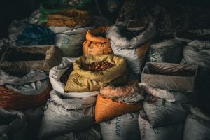 A variety of grains and spices in vividly colored sacks at an indoor market, providing rich textures.